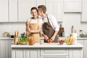 girl cooking in a bright kitchen with her boyfriend