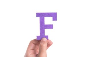 hand holding a letter F Made out of paper