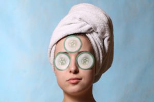 woman at a spa with cucumber slices on her face